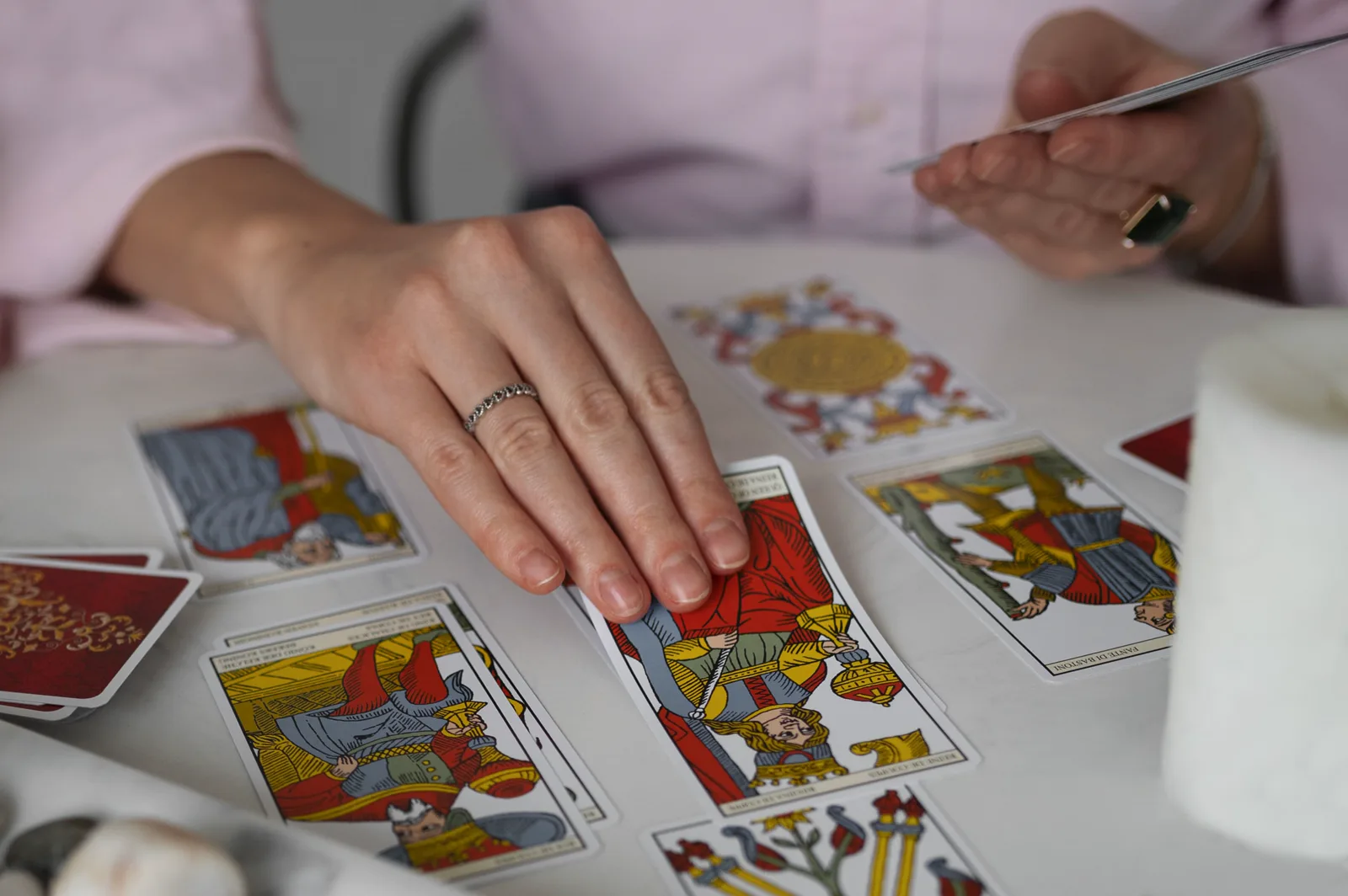 Manos echando las cartas del tarot sobre una mesa
